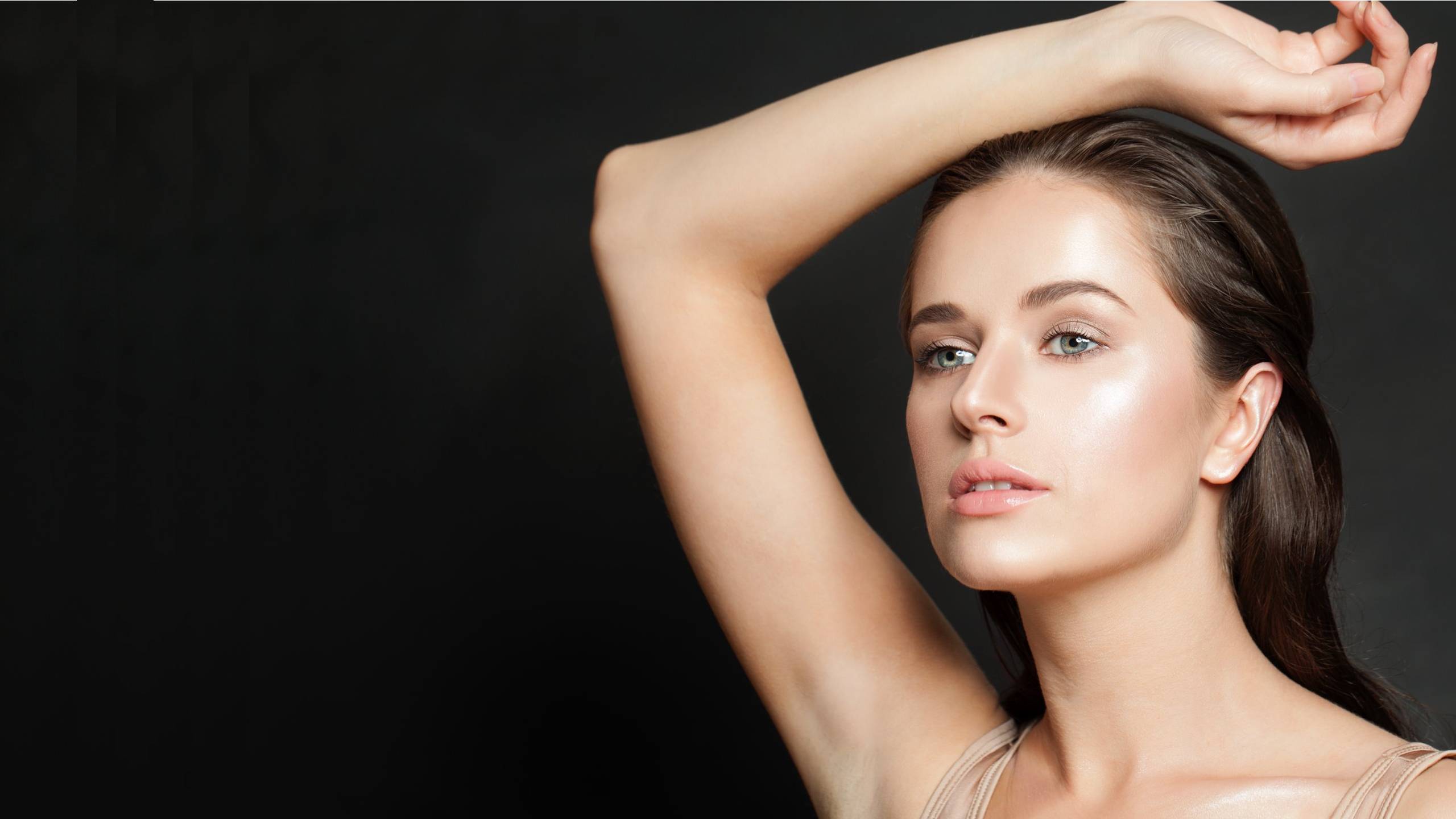 Beautiful woman with flawless skin rests raises her arm above her head and models skin rejuvenation treatments in Virginia.