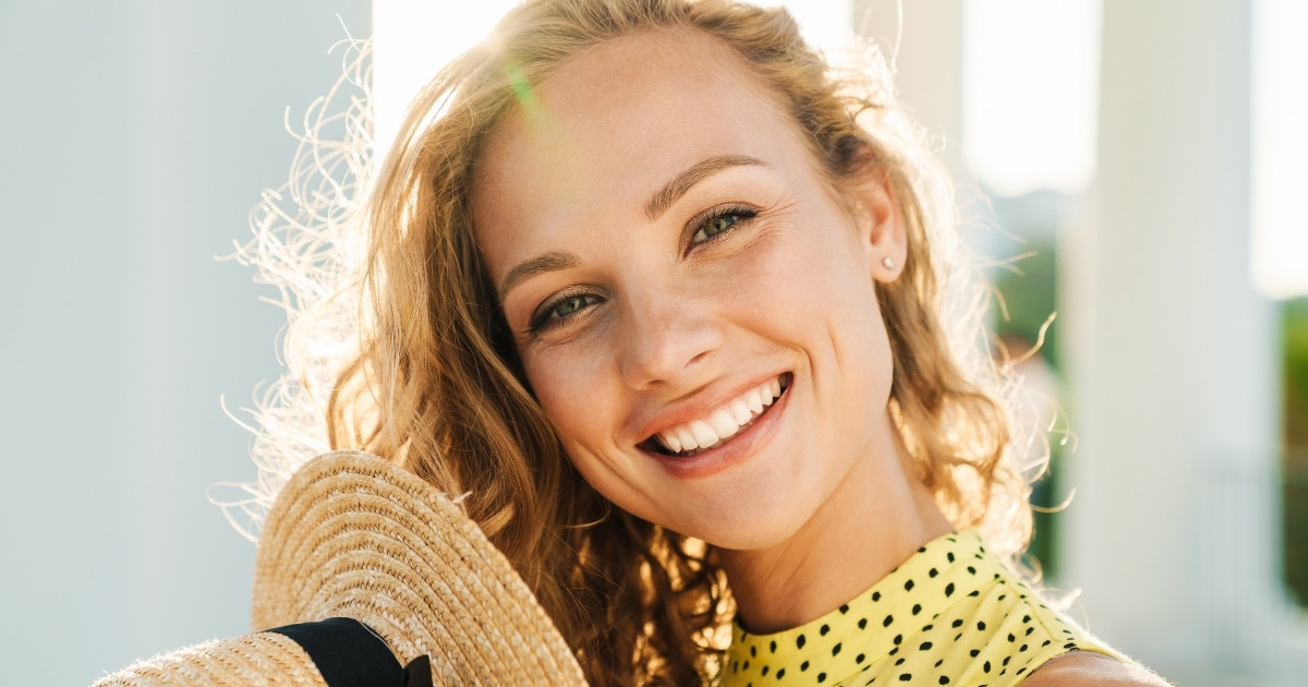Smiling woman enjoying her first med spa treatment consultation with healthy, glowing skin